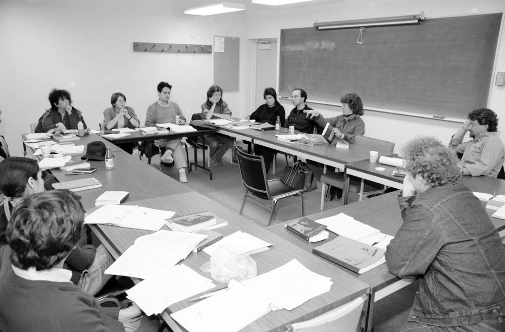 Black and white photo with professors and students in a conference setting